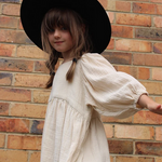 A little girl wearing a soft, flowy cotton dress with oversized puffed sleeves, ideal for casual outings, special occasions, and twirling fun | Dream Nu
