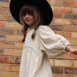 A little girl wearing a soft, flowy cotton dress with oversized puffed sleeves, ideal for casual outings, special occasions, and twirling fun | Dream Nu
