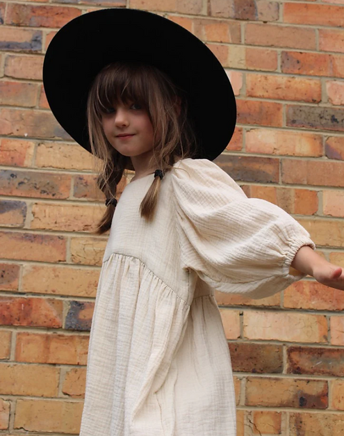 A little girl wearing a soft, flowy cotton dress with oversized puffed sleeves, ideal for casual outings, special occasions, and twirling fun | Dream Nu
